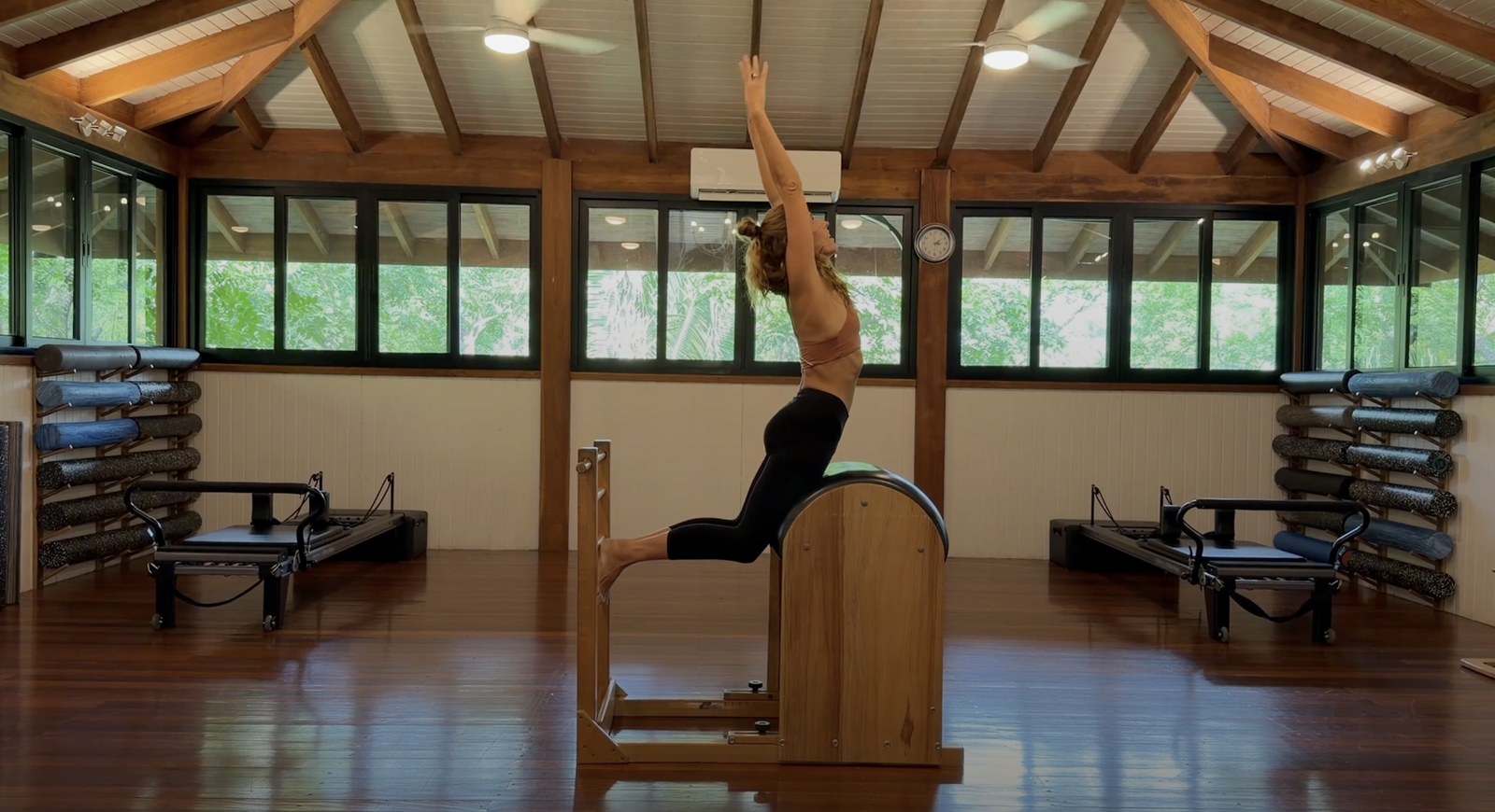 Pilates instructor demonstrating an exercise on a ladder barrel